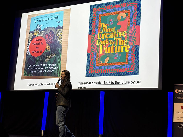 Hannah Smith on stage with two publication covers in the backgroud